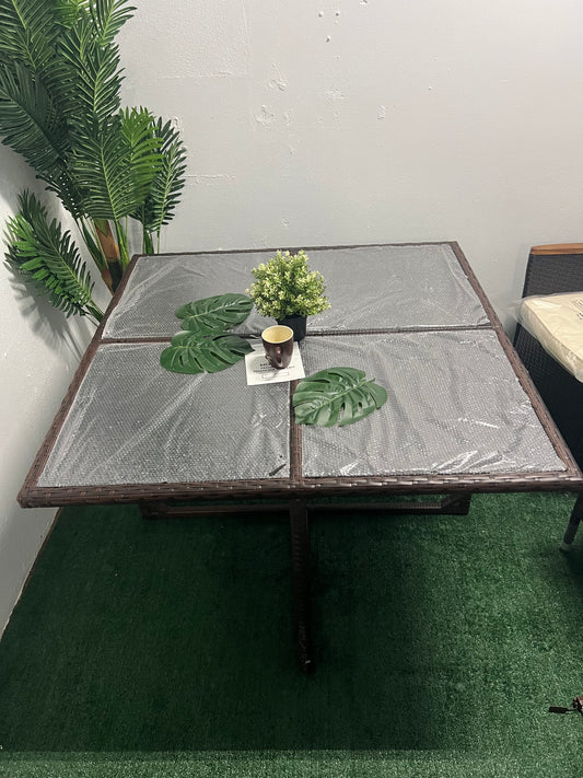 Mesa cuadrada marrón con mimbre y tope en cristal.